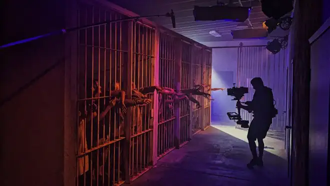 <i>A camera operator films actors inside the jail set. Courtesy of Ideal Sets.</i>